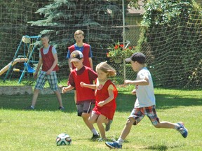 Assistant coaches Danny Kenyon (back left), and Cai Aldridge watch closely as Rhett Terpstra (left) and Ava Van Oostveen chase the ball in a game of soccer during the Upper Thames Missionary Church annual sports camp July 14-18. The camp included soccer, baseball and basketball and involved 50 participants. KRISTINE JEAN/MITCHELL ADVOCATE
