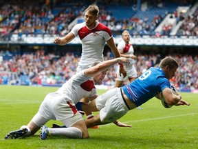 Scotland's Mark Bennett (R) scores a try as England's Philip Burgess attempts a tackle against Scotland during their men's rugby sevens semi-final at the 2014 Commonwealth Games in Glasgow, Scotland, July 27, 2014. (REUTERS)