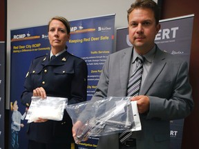 RCMP Cpl Sarah Knelsen and Staff Sgt. Martin Schiavetta of ALERT/Calgary City Police announce the arrest of Cory James Lesperance of the notorious Red Scorpion gang in Red Deer, Alta., on Monday July 28, 2014.
Various, guns, drugs and cash were also gathered during the arrest.
Mike Drew/Calgary Sun/QMI Agency