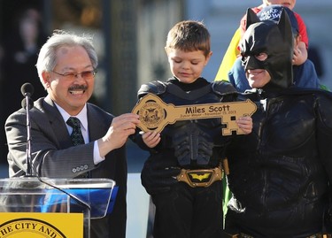 Five-year-old leukemia survivor Miles Scott, dressed as "Batkid" receive a key to the city declaring him "Junior Mayor" from San Francisco Mayor Ed Lee (L) during a ceremony as part of a day arranged by the Make- A - Wish Foundation in San Francisco, California November 15, 2013. The young cancer survivor was treated to various super hero scenarios including receiving a commendation at San Francisco City Hall.     REUTERS/Robert Galbraith