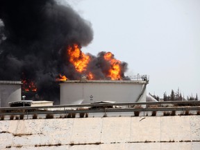 A general view shows fire burning at a fuel depot near the airport road in Tripoli July 29, 2014. Libyan forces on Tuesday battled Islamist militants with rockets and warplanes for control of an army base in the eastern city of Benghazi after at least 30 people were killed in overnight fighting. A rocket hit the fuel depot near Tripoli airport two days ago, igniting a huge blaze that Libyan fire-fighters on Tuesday were fighting to put out. Italy's government and Italian oil group ENI had agreed to help them, the government said.  REUTERS/Hani Amara