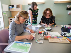 Concussion patient Brenda Lenders completes a puzzle while physiotherapist Shannon McGuire assists Marcia Gartly at different therapy stations at Parkwood Hospital. (DEREK RUTTAN/ The London Free Press)
