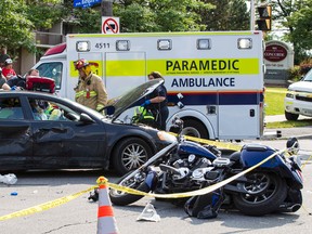 Ottawa Firefighters, and other emergency personnel, work at the scene of a fatal crash between a motorcycle and a car at the intersection of Montreal Road and Bathgate Drive in Ottawa. July 29, 2014. One person died after being taken to hospital.
Errol McGihon/Ottawa Sun/QMI Agency