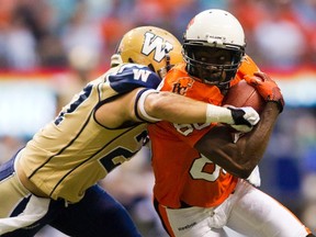 B.C Lions' Courtney Taylor (R) is tackled by Winnipeg Blue Bombers' Teague Sherman during the first half of their CFL football game in Vancouver, British Columbia, July 25, 2014. (REUTERS/Ben Nelms)