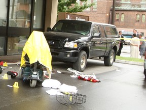 An Ottawa police officer gathers evidence at the scene of a downtown stabbing outside Embassy Suites Hotel early Wednesday morning, while a Major Crimes investigator takes statements from witnesses in the background.
DOUG HEMPSTEAD/Ottawa Sun