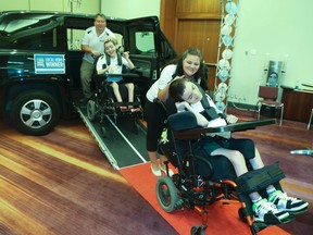 Sudbury parents Kyle and Paula Watson and twin sons Scott and Ian Watson, who are in wheelchairs due to cerebral palsy, check out their new Mobility Venture MV-1 on Wednesday, July 30, 2014. (Veronica Henri/Toronto Sun)