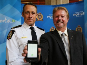 Minister of Municipal Affairs, Greg Weadick (r) and EPS Superintendent Kevin Galvin speaks to the media on the 44 cent levy in cell phobes to fund 911 call centres during a news conference at the downtown police headquarter in Edmonton, Alberta on July 30, 2014.  Perry Mah/Edmonton Sun