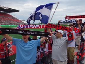 Sunday, July 20, 2014 Ottawa -- Waving banners and flags, members of the Bytown Boys Supporters Club get the crowd revved up at the first-ever soccer game played at TD Place on Sunday, July 20, 2014. The Fury FC lost to the NY Cosmos 1-0.MEGAN GILLIS/OTTAWA SUN/QMI AGENCY