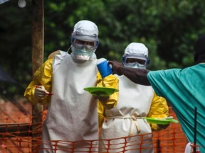 Medical staff working with Medecins sans Frontieres (MSF) prepare to bring food to patients kept in an isolation area at the MSF Ebola treatment centre in Kailahun, Sierra Leone July 20, 2014.  (REUTERS/Tommy Trenchard)