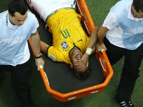 Brazil's forward Neymar is in pain after being injured during the quarter-final football match between Brazil and Colombia at the Castelao Stadium in Fortaleza during the 2014 FIFA World Cup on July 4, 2014. (AFP PHOTO / POOL / FABRIZIO BENSCH)