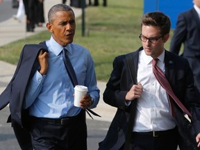 U.S. President Barack Obama (L) talks with travelling aide Bobby Schmuck (R) as he departs after meeting with wounded armed service members at Walter Reed National Military Medical Center in Bethesda, Maryland July 29, 2014. REUTERS/Jonathan Ernst