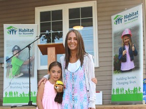 Megan Johnson and her eight-year old daughter Tori stand in front of their new Habitat for Humanity Home in Sarnia on July 31. Johnsons' 1,080-sqaure foot Habitat home was built in partnership with Lambton College students and faculty, who, along with volunteers, completed the construction that began last September. (CARL HNATYSHYN, QMI Agency)
