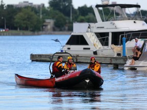 An Ottawa Fire rescue boat drags a canoe to shore at Dow's Lake Thursday night after three young men went into the Rideau Canal after their canoe tipped. All three were safe. (Chris Hofley/Ottawa Sun)