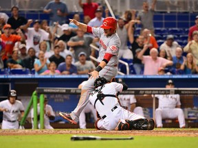 Cincinnati Reds shortstop Zack Cozart is tagged out by Miami Marlins catcher Jeff Mathis at home plate during the eighth inning at Marlins Ballpark on July 31, 2014. (Steve Mitchell/USA TODAY Sports)