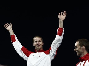 Commonwealth Games high jump gold medalist Canada's Derek Drouin (L) celebrates on the podium with bronze medalist Canada's Michael Mason (R) during the award ceremony for the event at Hampden Park during the 2014 Commonwealth Games in Glasgow, Scotland on July 30, 2014. Drouin has risen quickly over the last few track and field seasons and has become one of Sarnia-Lambton's most decorated athletes of all time. AFP PHOTO / ADRIAN DENNIS