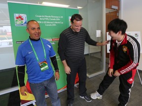 From left to right, Brazil coach Adilson Galdino dos Santos, United States official James Moorhouse, and China official Fred Li share a laugh during a visit to Commonwealth Stadium last March in prepartion for the 2014 FIFA U20 Women’s World Cup. Perry Mah/Edmonton Sun