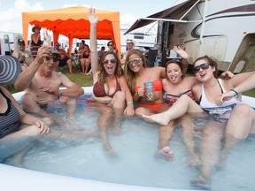 Slave Lake residents the Lucan family, along with Broad family friends, party in an inflatable tub during Big Valley Jamboree 2014 in Camrose, Alta., on Thursday, July 31, 2014. They maintain a setup called the Crow Bar at their campsite. Ian Kucerak/Edmonton Sun/QMI Agency