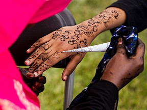 Idil Abdi, left, paints henna on Ladane Moussa during Eid celebrations at 118 Avenue and 91 Street in Edmonton, Alta., on Saturday, Aug. 2, 2014. Codie McLachlan/Edmonton Sun/QMI Agency