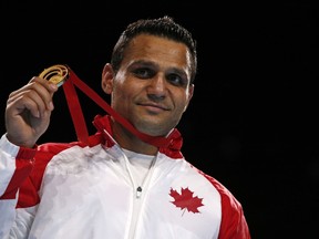 Canada's gold medalist Samir El-Mais poses on the podium with his medal after the men's heavy (91kg) final boxing bout at the 2014 Commonwealth Games in Glasgow, Scotland, on August 2, 2014. AFP PHOTO/ADRIAN DENNIS