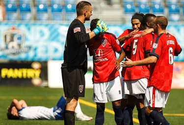 Thrill of victory, the agony of defeat. Edmonton forward Daryl Fordyce (16) reacts as Indy players celebrate their win in extra time at the conclusion of a NASL soccer game between FC Edmonton and the Indy Eleven at Clark Stadium in Edmonton, Alta., on Sunday, July 27, 2014. The Eddies lost 0-1 in extra time. Ian Kucerak/Edmonton Sun/QMI Agency