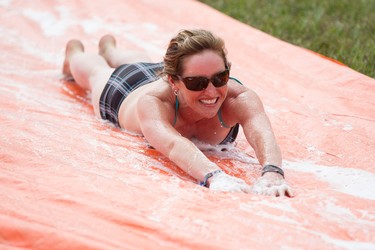 Ashley Steeves from Darwell, Alta., rides a makeshift slip and slide in the campground during Big Valley Jamboree 2014 in Camrose, Alta., on Sunday, Aug. 3, 2014. Ian Kucerak/Edmonton Sun/QMI Agency