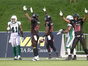 OTTAWA, ON, CANADA - AUGUST 2: Dobson Collins #80 of the Ottawa Redblacks celebrates a touchdown with teammates Wallace Miles #84 and Marcus Henry #16 as Tyron Brackenridge #41 of the Saskatchewan Roughriders looks on during a CFL game at TD Place Stadium on August 2, 2014 in Ottawa, Ontario, Canada.   Andre Ringuette/Freestyle Photography/Getty Images/AFP== FOR NEWSPAPERS, INTERNET, TELCOS & TELEVISION USE ONLY ==