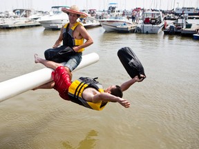 Winnipegger Jamison Vann knocks a competitor off the pole and into Gimli Harbour during the Islendingadunk competition at the 125th running of the Islandic Festival of Manitoba held in Gimli, Man., on Sat., Aug. 2, 2014. (Brook Jones/QMI Agency)