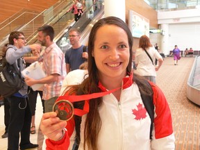 Weightlifter Marie-Josee Ares-Pilon from Lorette shows off her Commonwealth Games bronze medallist at the James Armstrong Richardson International Airport on Friday, Aug. 1, 2014. Ares-Pilon won the bronze medal in the women’s 69-kg weightlifting at the Commonwealth Games in Glasgow, Scotland on July 28, 2014. (GLEN DAWKINS/Winnipeg Sun/QMI Agency.)