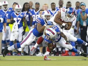 Inside linebacker Preston Brown #52 and cornerback Ron Brooks #33 of the Buffalo Bills tackle running back Rashad Jennings #23 of the New York Giants during the second quarter at the 2014 NFL Hall of Fame Game at Fawcett Stadium on August 3, 2014 in Canton, Ohio.  Jason Miller/Getty Images/AFP