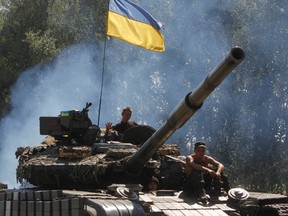 Ukrainian soldiers ride on a tank as they patrol the area near eastern Ukrainian town of Debaltseve Aug. 3, 2014. REUTERS/Valentyn Ogirenko