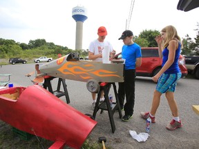 Though brother and sister Nicholas and Emily MacDonald, 14 and 12, of Kingston, Ont. are no stranger to soap box racing, the pair, seen here putting the last touch to their racing machines with their father Rick, were looking forward to race Mill Street at this year's Consecon Community Day Saturday, Aug. 2, 2014. — Jerome Lessard/The Intelligencer/QMI Agency