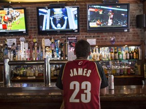 Cleveland Cavaliers fan wearing a Lebron James jersey watches news coverage of LeBron James return to Cleveland at Panini's Bar and Grille in downtown Cleveland on July 11, 2014 in Cleveland, Ohio  (Angelo Merendino/Getty Images/AFP)