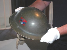 Elgin Military Museum volunteer Greg Kerr holds a Brodie Helmet used by soldiers in the First World War. The helmet is part of a large exhibit that coincides with the 100th anniversary of the start of the war. The exhibit seeks to preserve the stories of people from Elgin and St. Thomas who contributed to the war effort. 
Ben Forrest/Times-Journal