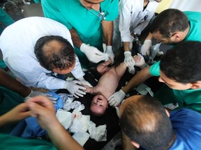 Palestinian medics treat an infant, whom medics said was wounded in an Israeli air strike, at a hospital in Rafah in the southern Gaza Strip August 4, 2014. (Reuters)