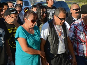 Jimmy Crowshoe, Colton's father, leads a group of mourners into the community hall for his son's candlelight vigil. File photo.