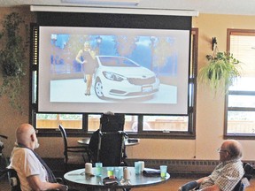 A 12-foot drop down screen with a high definition projector was recently installed at the Vulcan Extendicare. With a surround sound system and large screen, residents will be able to see and hear from anywhere in the lobby. Here, a couple residents watch The Price is Right.  
Simon Ducatel Vulcan Advocate