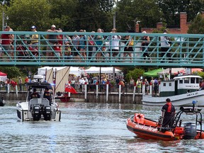 Boats slide underneath the Wallaceburg walking bridge on Saturday, August 10, 2013, as people on the bridge look on during the Wallaceburg Antique and Motor Boat Outing.
DAVID GOUGH/COURIER PRESS/QMI AGENCY