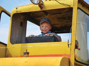 Ryder Oczkowski, 4, could not get enough of the old farm vehicles on display at Heritage Acres Farm Museum  during their early transportation-themed annual show. John Stoesser photos/QMI Agency.