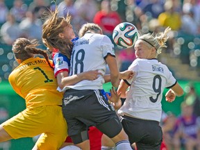 Germany’s Pauline Bremer (right) and Lena Petermann jump to head the ball against USA goalkeeper Katelyn Rowland during last night’s game in Edmonton. The Germans won the game 2-0 to go atop Group B. (QMI AGENCY)