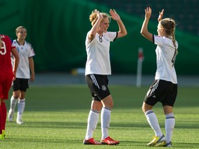 Germany's Rebecca Knaak (8) and Margarita Gidion (4) celebrate beating the USA 2-0 in FIFA U-20 World Cup play at Commonwealth Stadium in Edmonton Alta., on Aug. , 2014. Ian Kucerak/Edmonton Sun/ QMI Agency