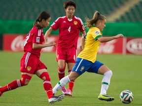 Brazil's Andressa Cavalari Machry plays keepaway from a couple of China's defenders during the opening-night game at Commonwealth Stadium (Ian Kucarek, Edmonton Sun).