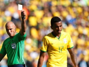 Brazil's Luiz Gustavo (R) receives a yellow card from referee Howard Webb of England during their 2014 World Cup round of 16 game against Chile at the Mineirao stadium in Belo Horizonte June 28, 2014. (REUTERS/Toru Hanai)