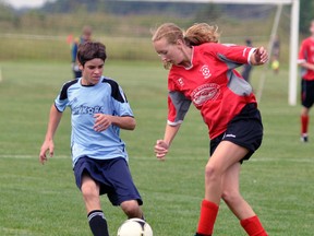 Laura Vink (right) of the Mitchell U15 soccer team kicks the ball away from Kinkora’s Shawn Van Herk during the Inter-county ‘A’ tournament at the Parmalat fields in Mitchell July 26. ANDY BADER/MITCHELL ADVOCATE