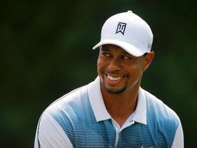 Tiger Woods of the United States smiles while warming up on the practice range at the 2014 PGA Championship at Valhalla Golf Course in Louisville, Kentucky August 6, 2014.    REUTERS/Brian Snyder