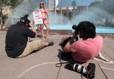 Newspaper photographers take photos of Tanis Jex-Blake as she poses outside City Hall during a Bare Your Belly protest, in Edmonton Alta., on Wednesday Aug. 6, 2014. Jex-Blake says she was recently bullied at a local beach for wearing a bathing suit that revealed her pregnancy stretch marks. David Bloom/Edmonton Sun/QMI Agency