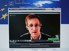 File photo of accused government whistleblower Edward Snowden seen on the computer screen of a journalist as he speaks via video somewhere in Moscow, with the Council of Europe in Strasbourg, during an hearing on "mass surveillance", April 8, 2014. Former U.S. intelligence contractor Edward Snowden has received a three-year residence permit from Russia, his Russian lawyer told reporters August 7, 2014.  REUTERS/Vincent Kessler/Files