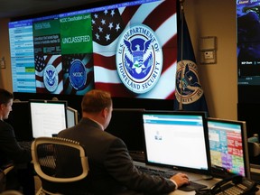 U.S. Department of Homeland Security employees work in front of U.S. threat level displays inside the National Cybersecurity and Communications Integration Center during a guided media tour in Arlington, Va. June 26, 2014. REUTERS/Kevin Lamarque