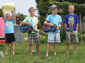 Four young local entertainers, ages 6-8, were 'singing and making music for donations to the London Children's Hospital (for sick kids)' Thursday on the corner of Tulip Drive and South Ridge Road. From left are Zach Nichols, Josh Allen (lead singer), Eric Allen and Brenden Nichols singing one of their most played songs, Old Grandpa. Using Facebook to help spread the word, they had many visitors between 11:30 a.m. to 3 p.m. and successfully raised $150. CHRIS ABBOTT/TILLSONBURG NEWS