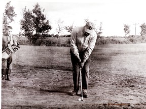 George Young tests his nerve on one of the sand greens at the old Stony golf course, while his unidentified caddie looks on. - Photo Supplied