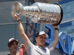 Los Angeles Kings president of business operations Luc Robitaille hoists the Stanley Cup during a parade on Figueroa Street to celebrate winning the 2014 Stanley Cup on Jun 16, 2014 in Los Angeles, CA, USA. (Kirby Lee/USA TODAY Sports)